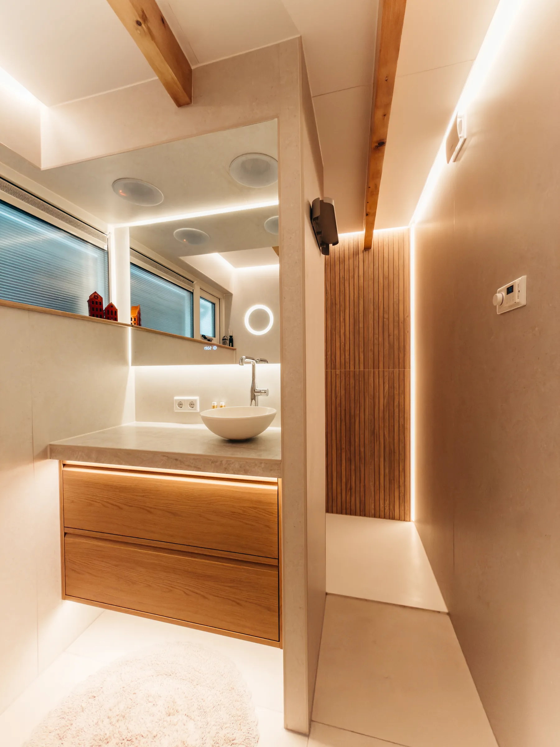 Badkamer met wastafel en gang naar de douche in avondsfeer