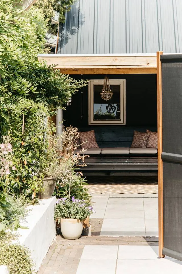 Buitenkant van het Tiny House met entree en groen