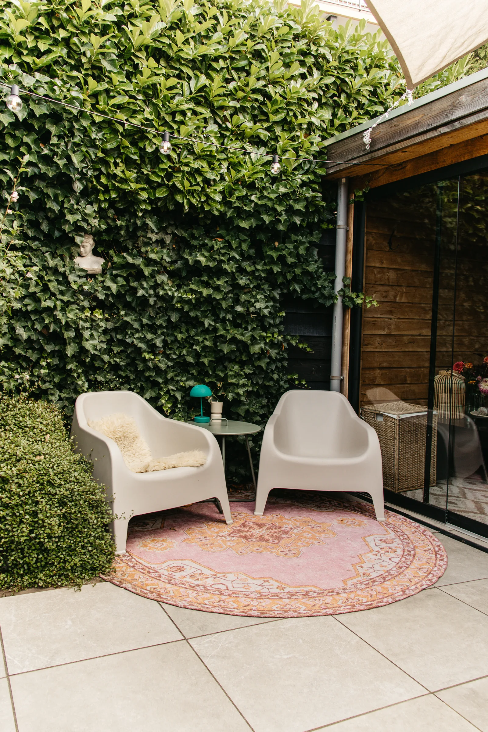 Loungehoek op het terras bij de klimopmuur