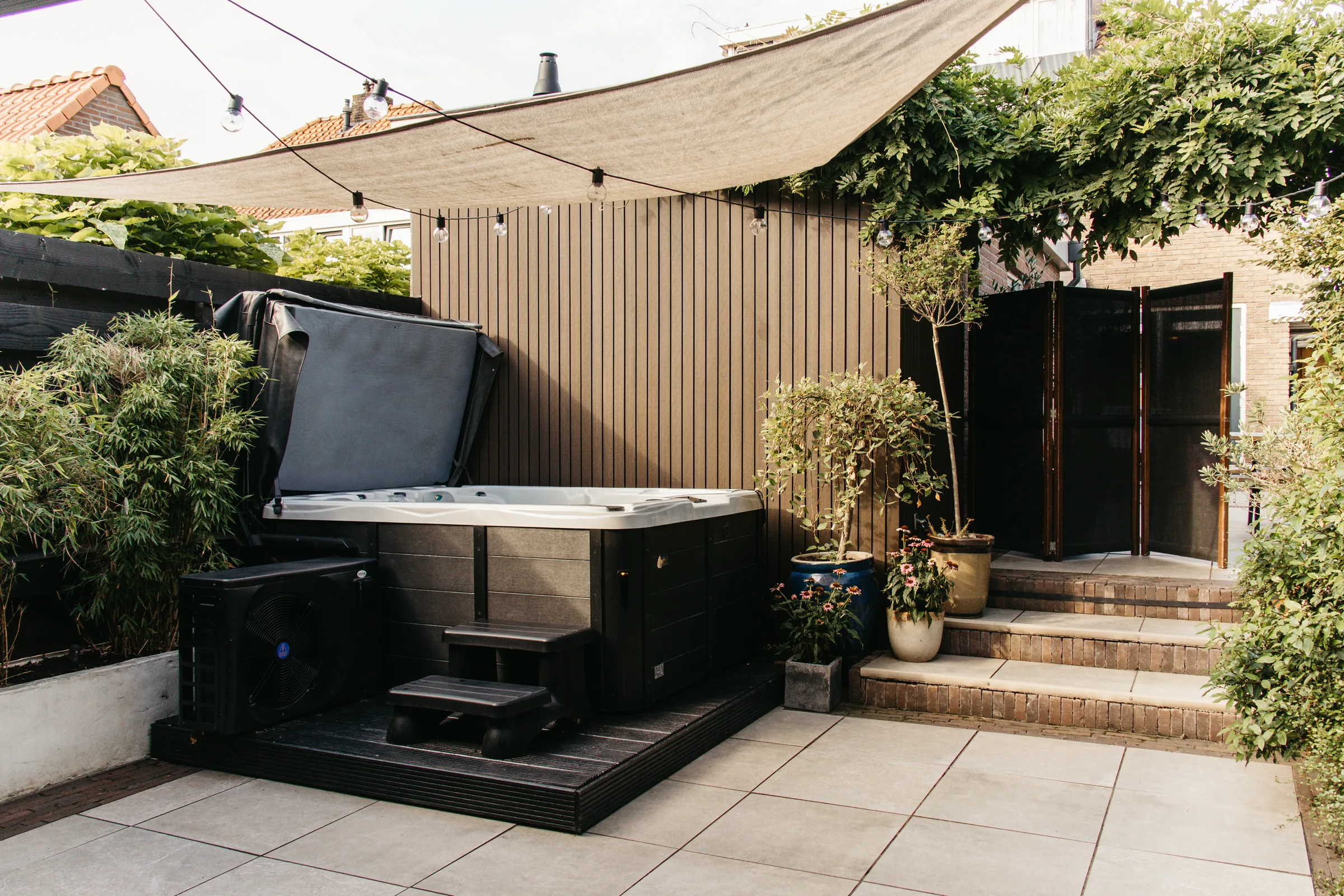 Overzicht van het terras met de privéjacuzzi en zonnescherm