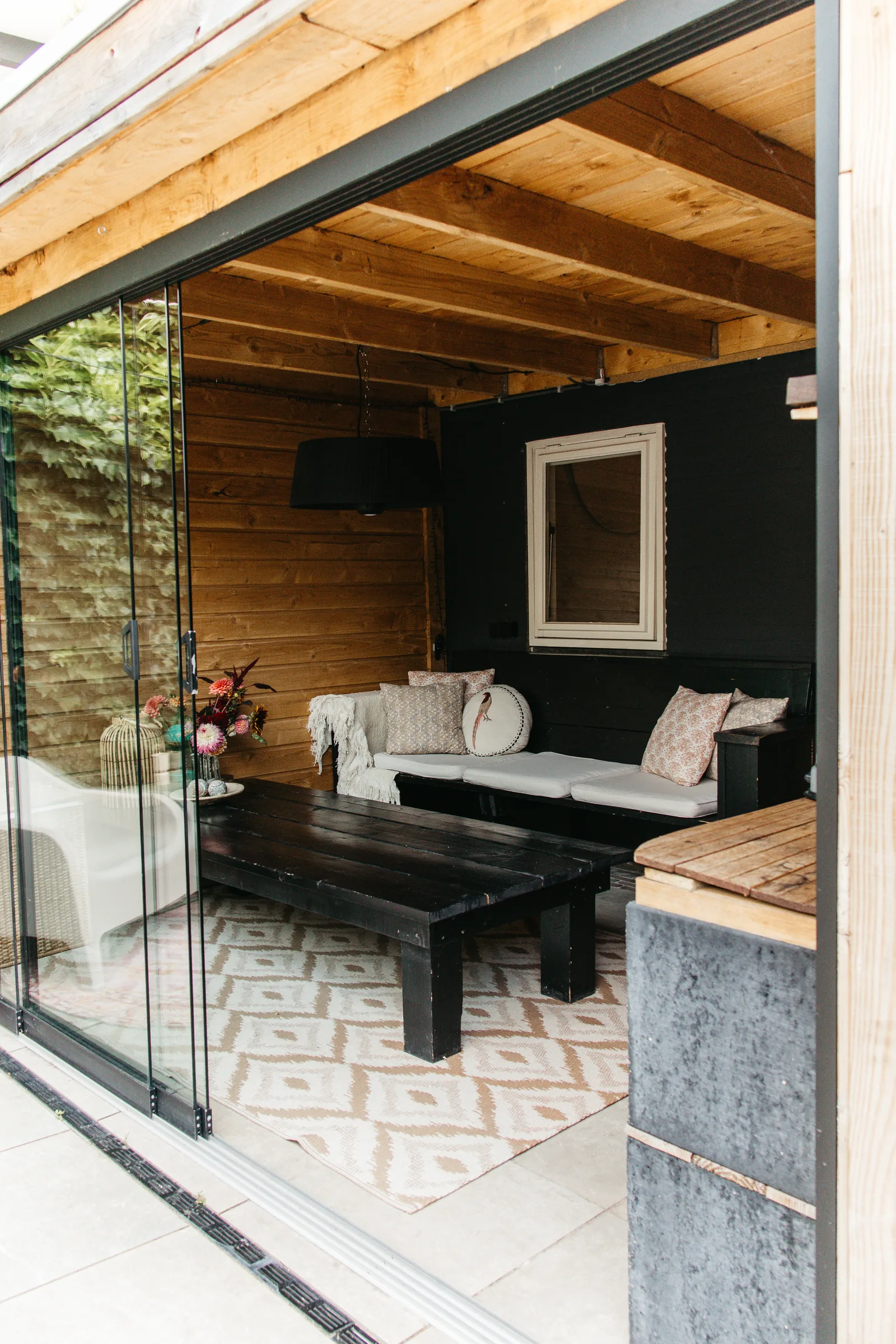Zithoek met bank en kussens in de verwarmde tuinkamer