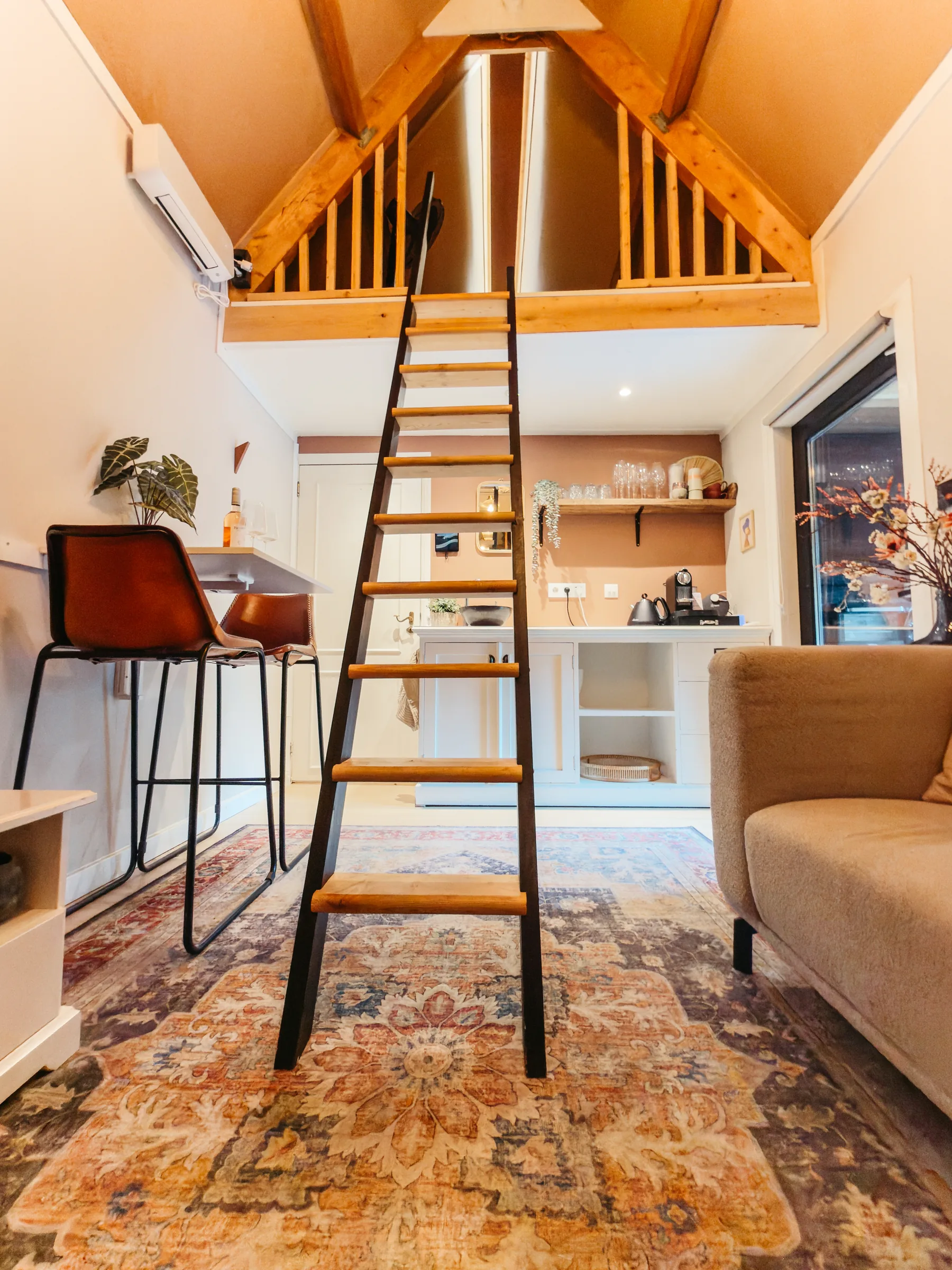 Woonkamer met ladder naar de slaapvide in avondsfeer